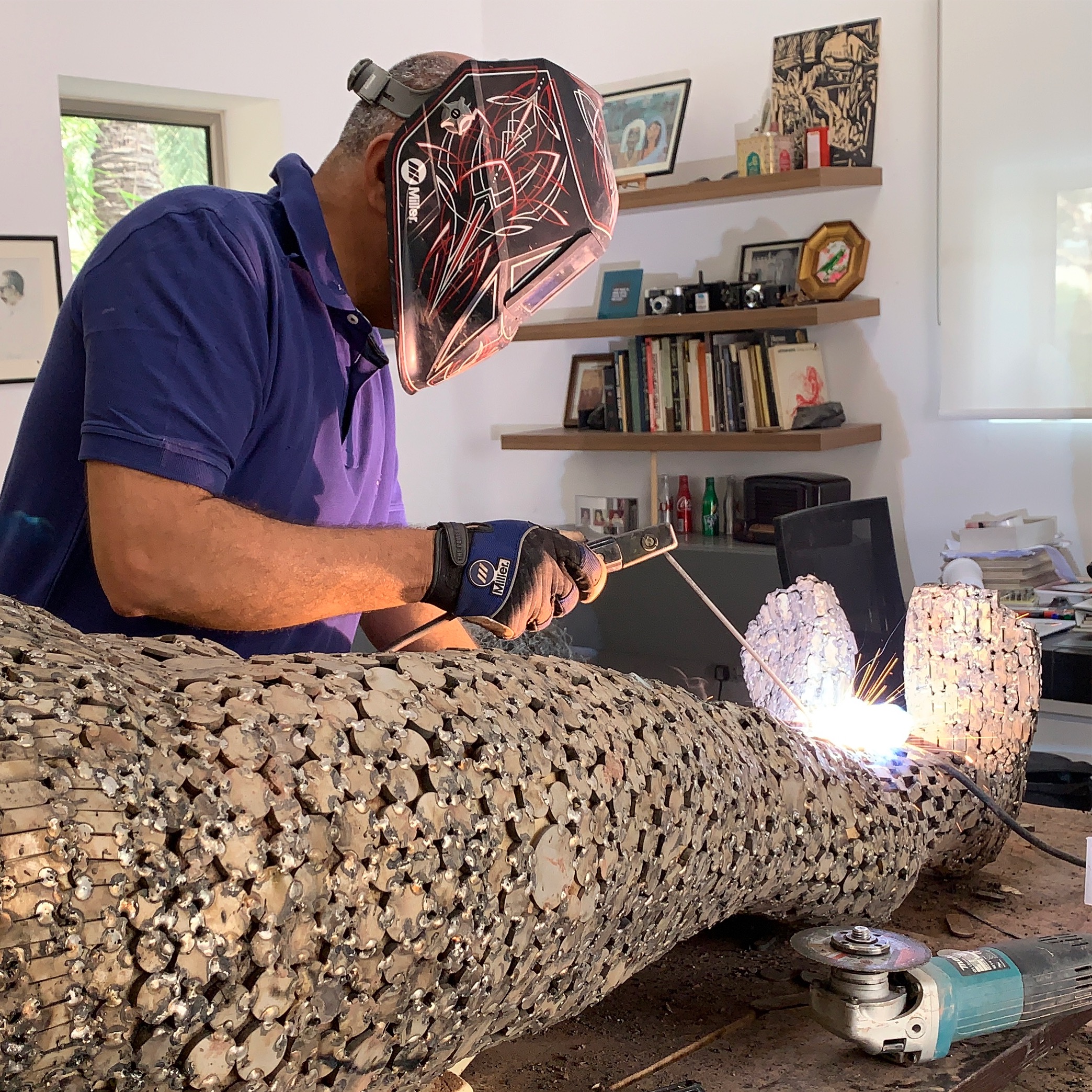 Jamal AlYousif welding a stainless steel sculpture