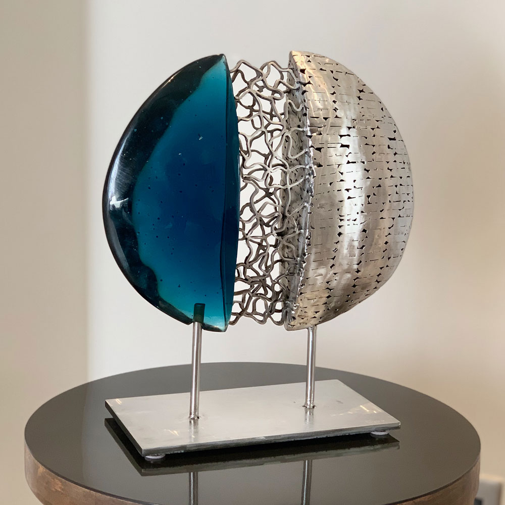 Mixed media sphere sculpture combining blue glass and steel mesh